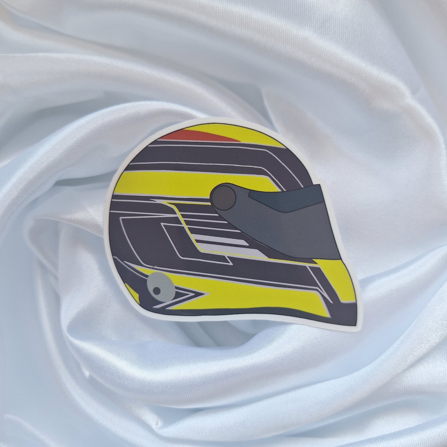 Sergio Pérez 2026 Formula 1 helmet sticker featuring a yellow, black and grey racing helmet design on a white background.
