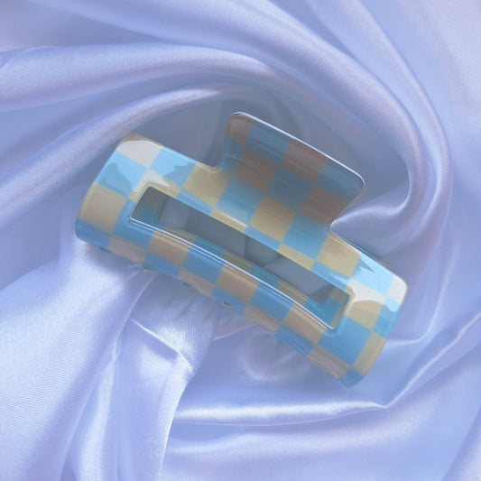 Blue and cream gingham check hair claw clip displayed on a white satin background.