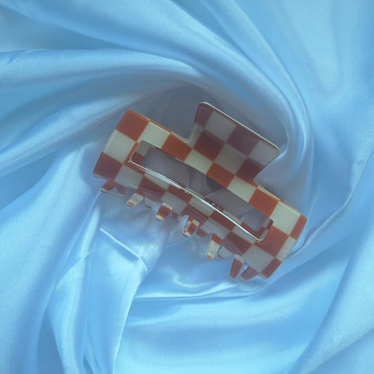 Brown and cream gingham check hair claw clip displayed on a white satin background.