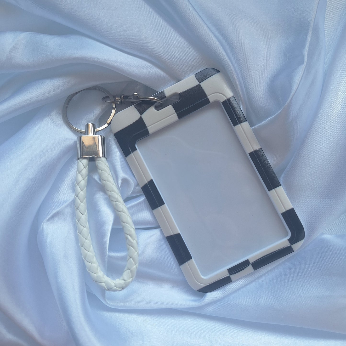 Black and white checkered ID card holder with matching white wrist strap inspired by motorsport racing flags.