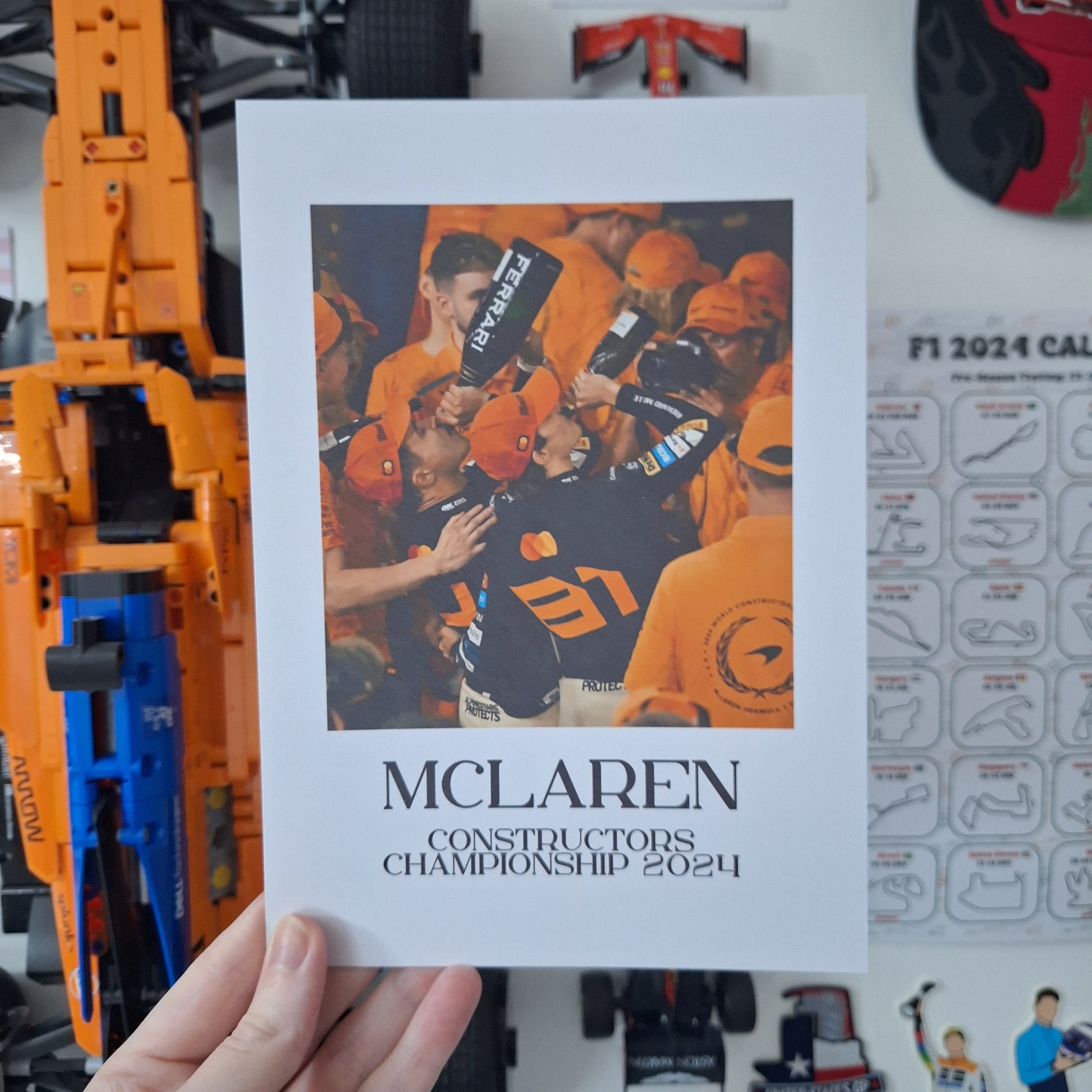 McLaren Constructors' Championship 2024 Formula 1 print featuring championship celebrations in papaya orange, printed on premium cardstock.