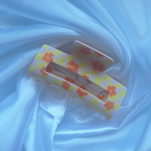 Yellow gingham hair claw clip with orange floral details and checkered racing pattern